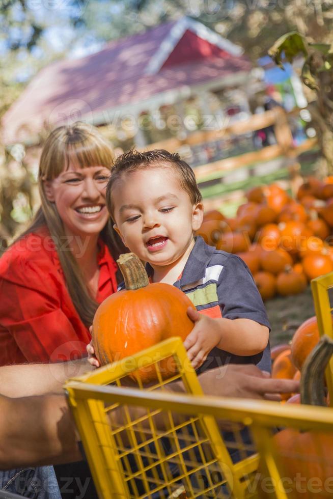 famille métisse heureuse au champ de citrouilles photo