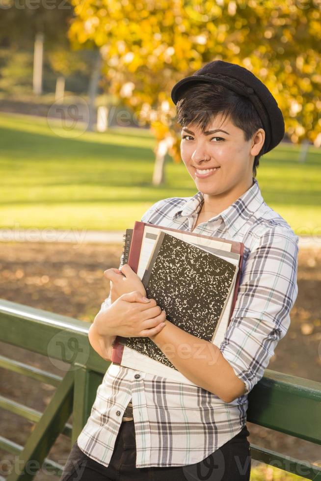 portrait d'une jolie étudiante métisse tenant des livres photo