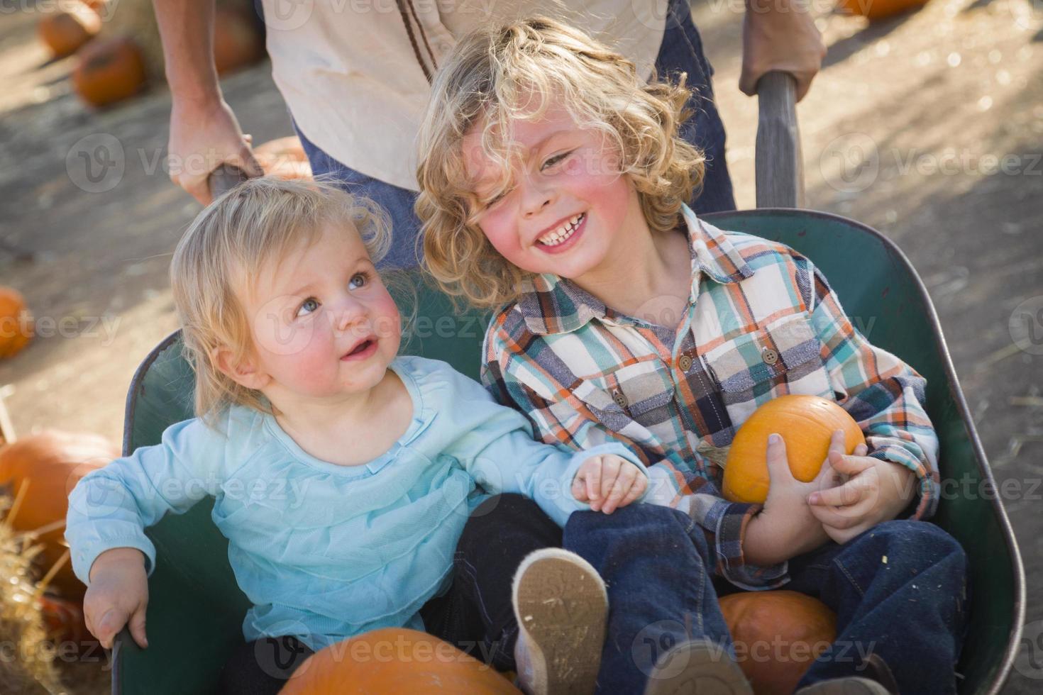 jeune famille profite d'une journée au champ de citrouilles photo