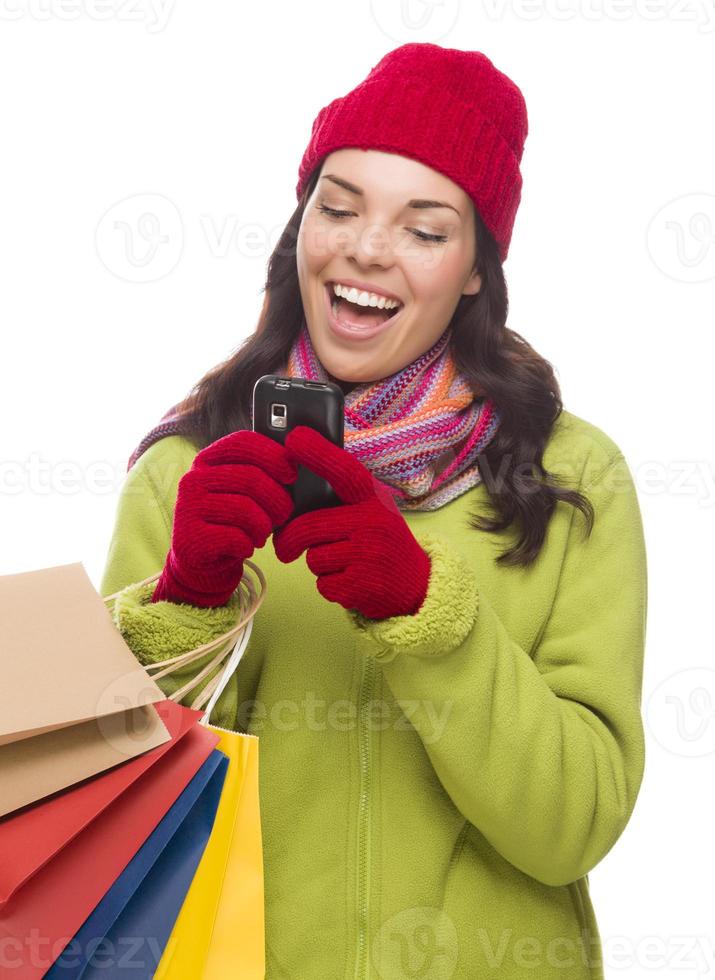 femme de race mixte tenant des sacs à provisions textos sur téléphone portable photo