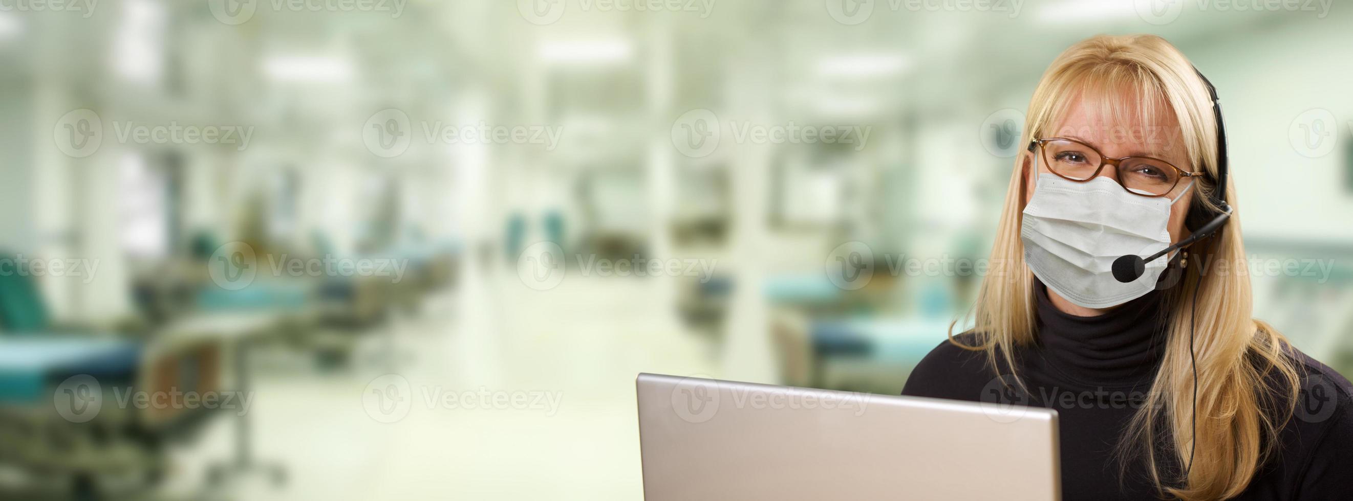 femme assise devant un ordinateur avec un casque téléphonique à l'intérieur de l'hôpital. photo