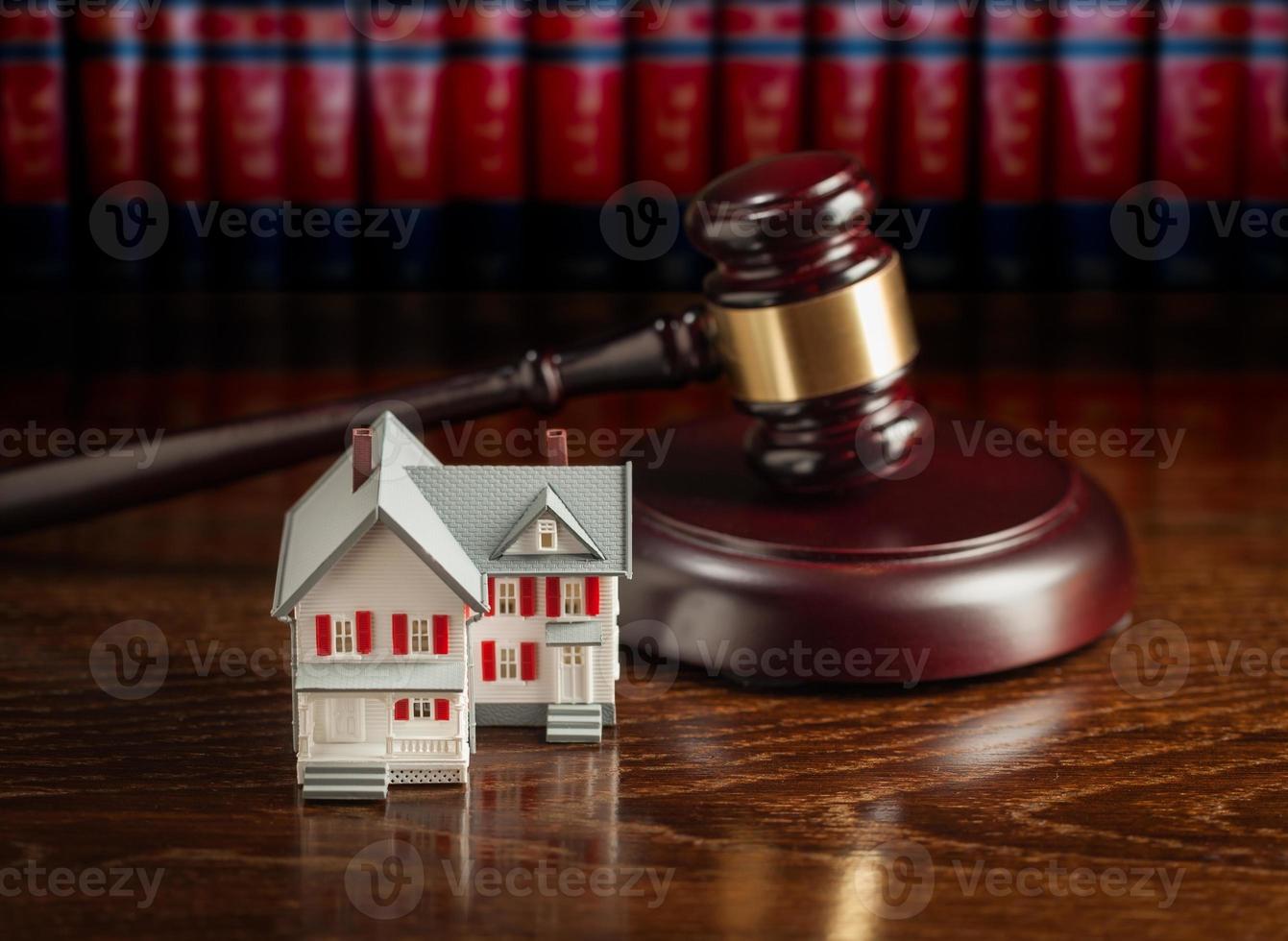 marteau et petite maison modèle sur table en bois. photo