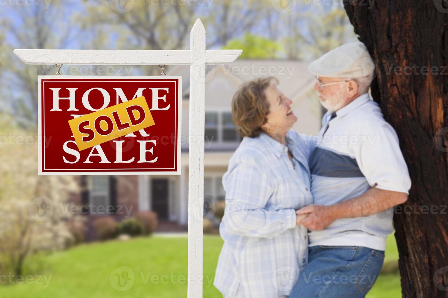 signe immobilier vendu avec un couple de personnes âgées devant la maison photo