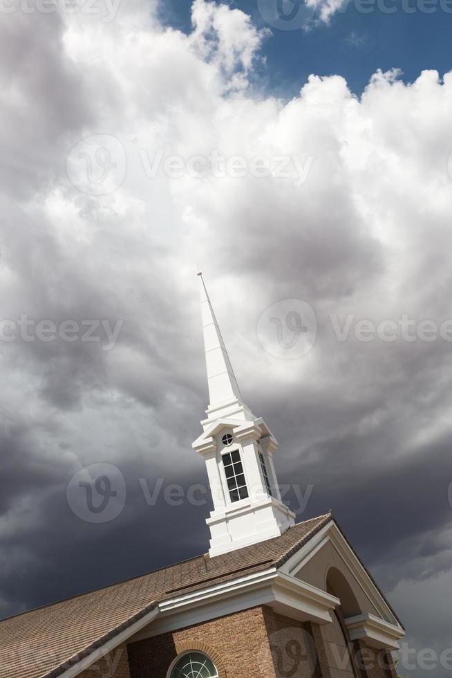 clocher de l'église au-dessous des nuages d'orage orageux inquiétants. photo