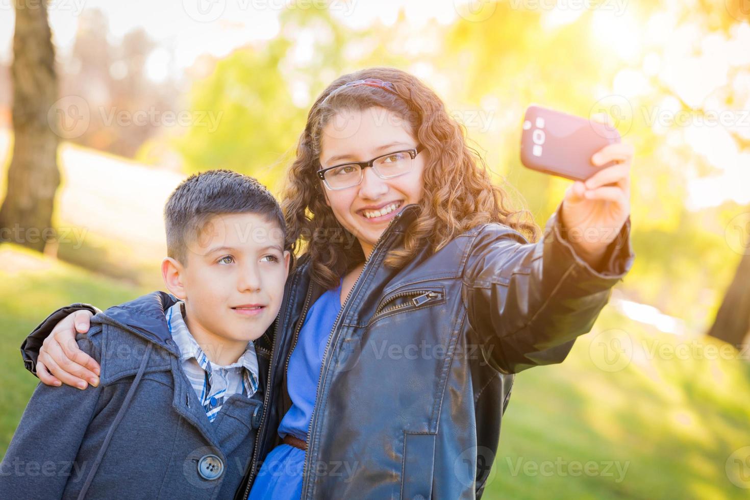 frère et soeur hispaniques prenant le selfie avec le téléphone portable photo