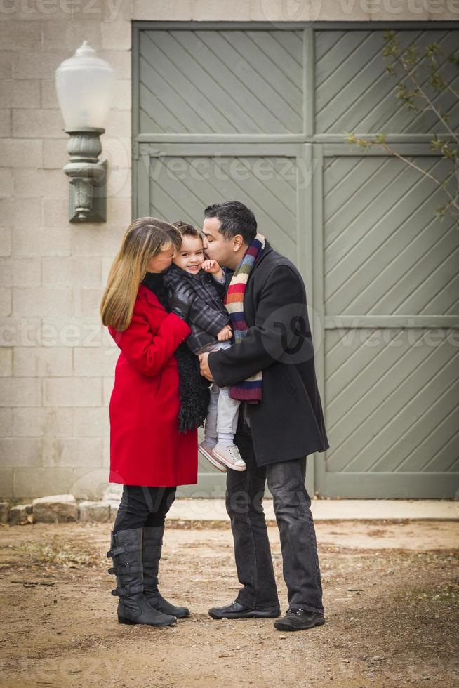 fils aimant la famille habillé chaleureusement devant un bâtiment rustique photo