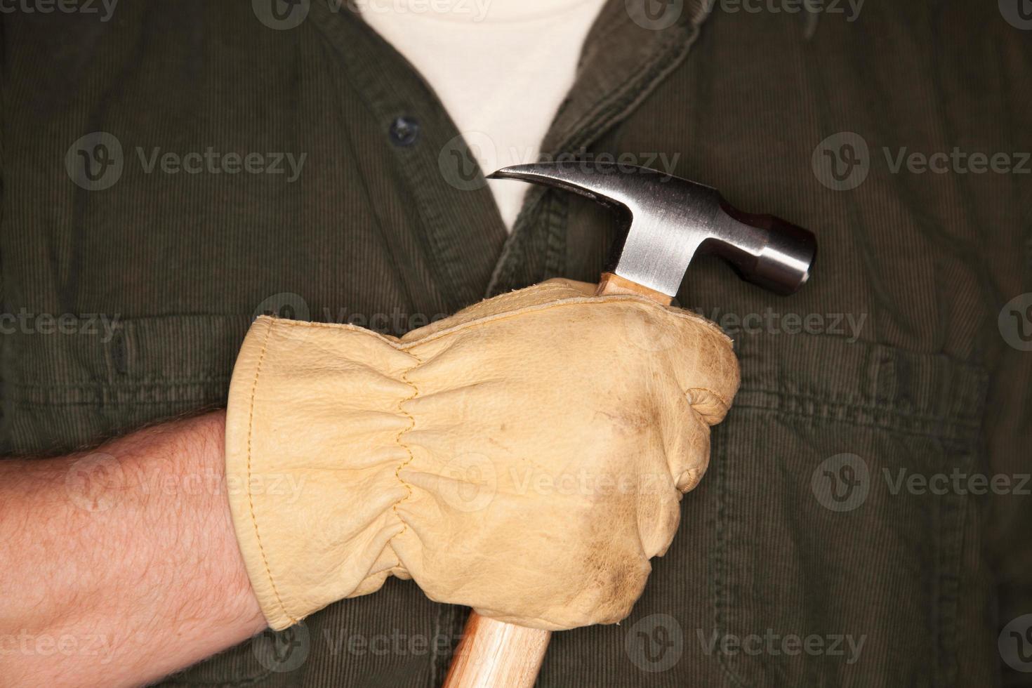 homme avec un gant de construction en cuir tenant un marteau photo