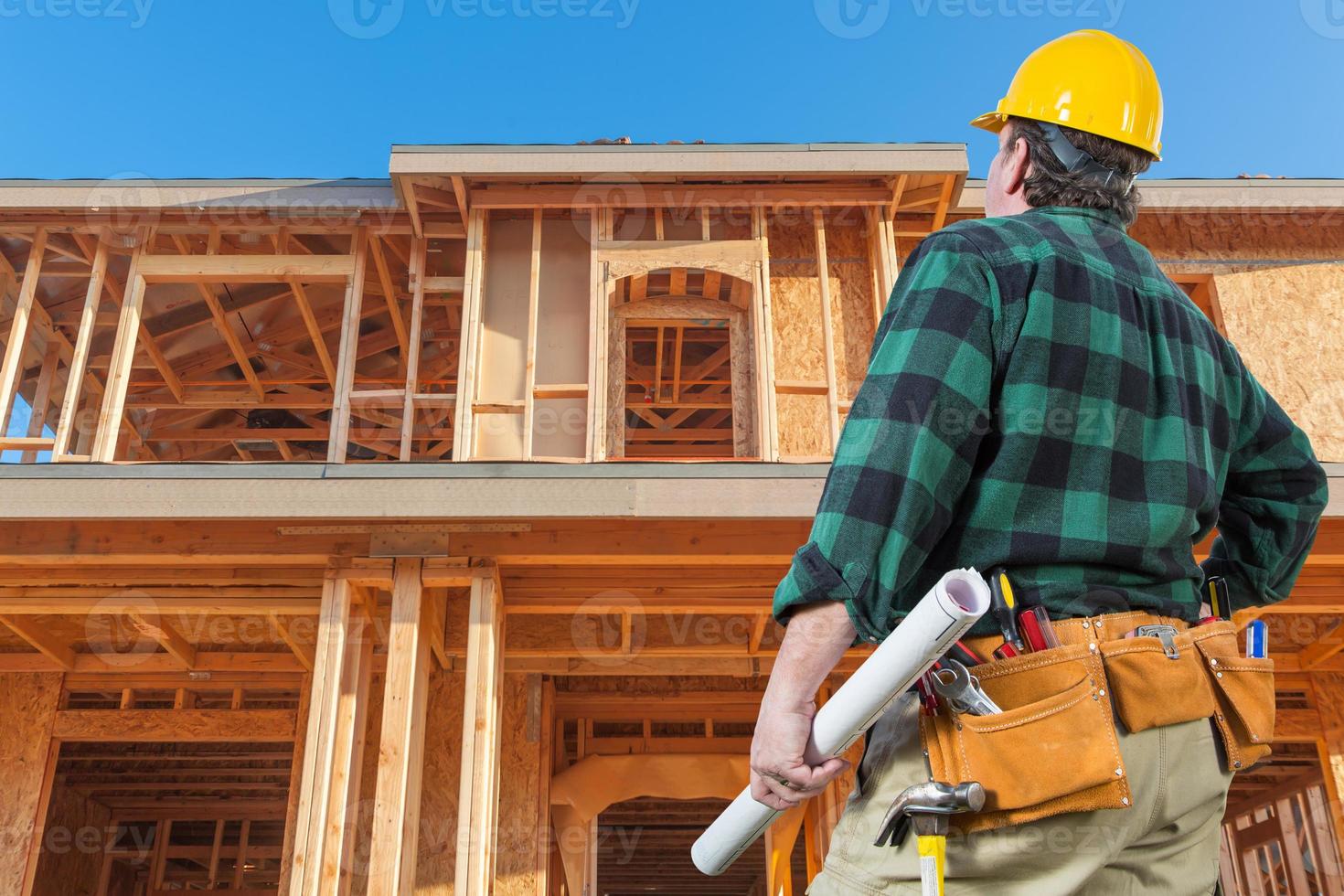 entrepreneur avec ceinture à outils et casque de sécurité devant