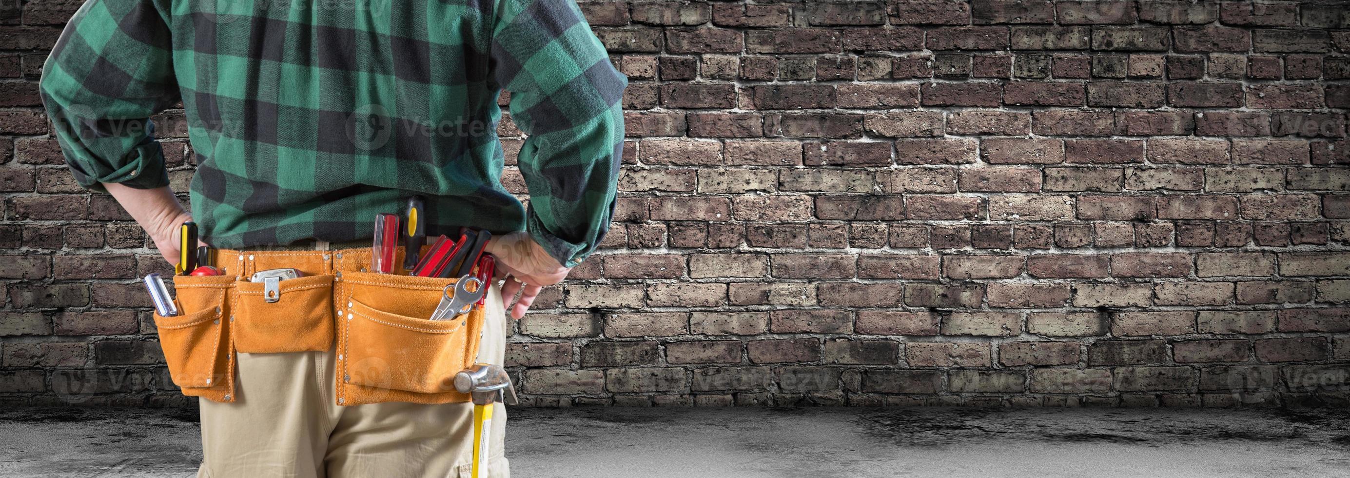 entrepreneur avec ceinture à outils et casque de sécurité devant