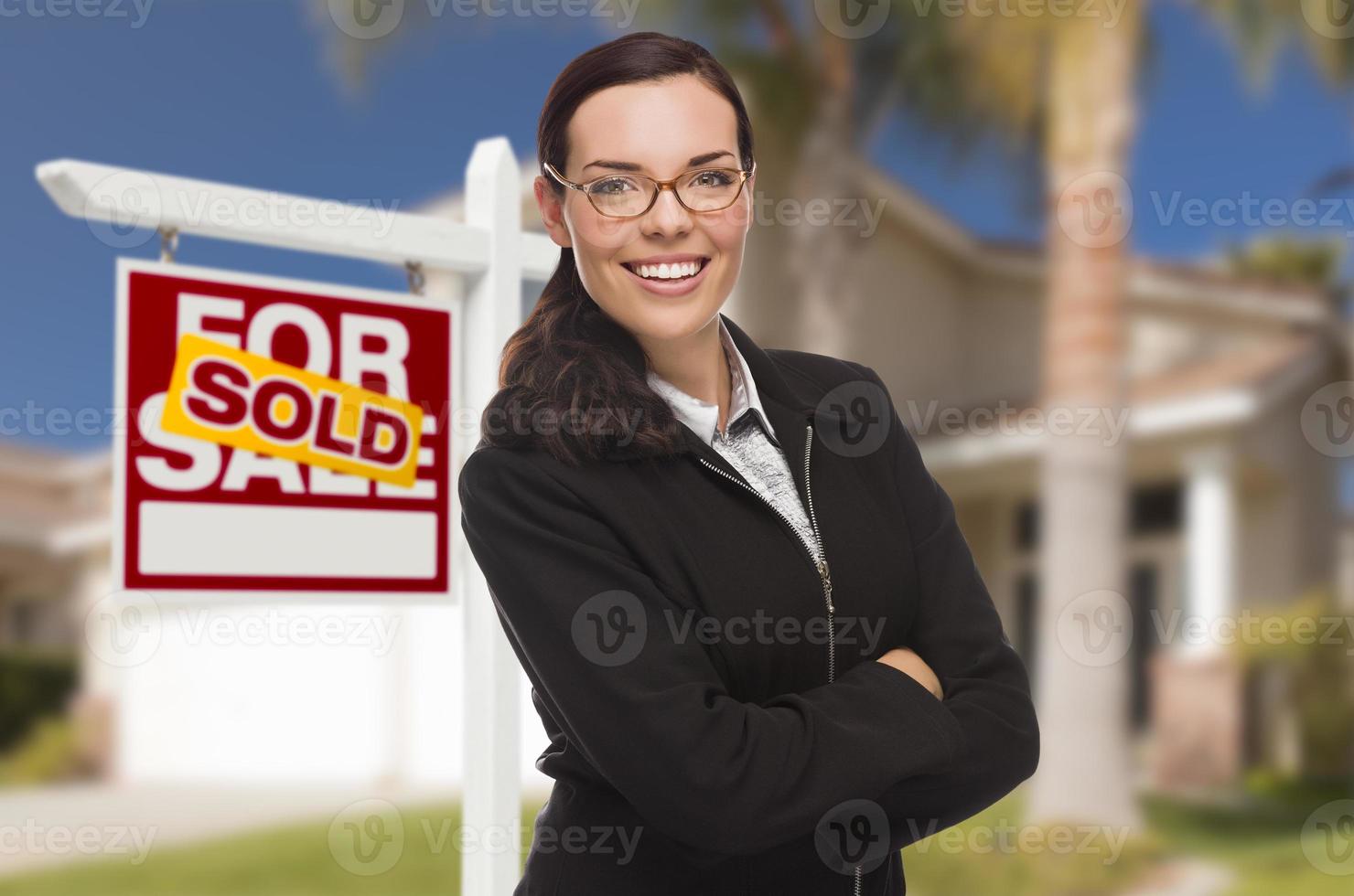 femme métisse devant la maison et signe vendu photo