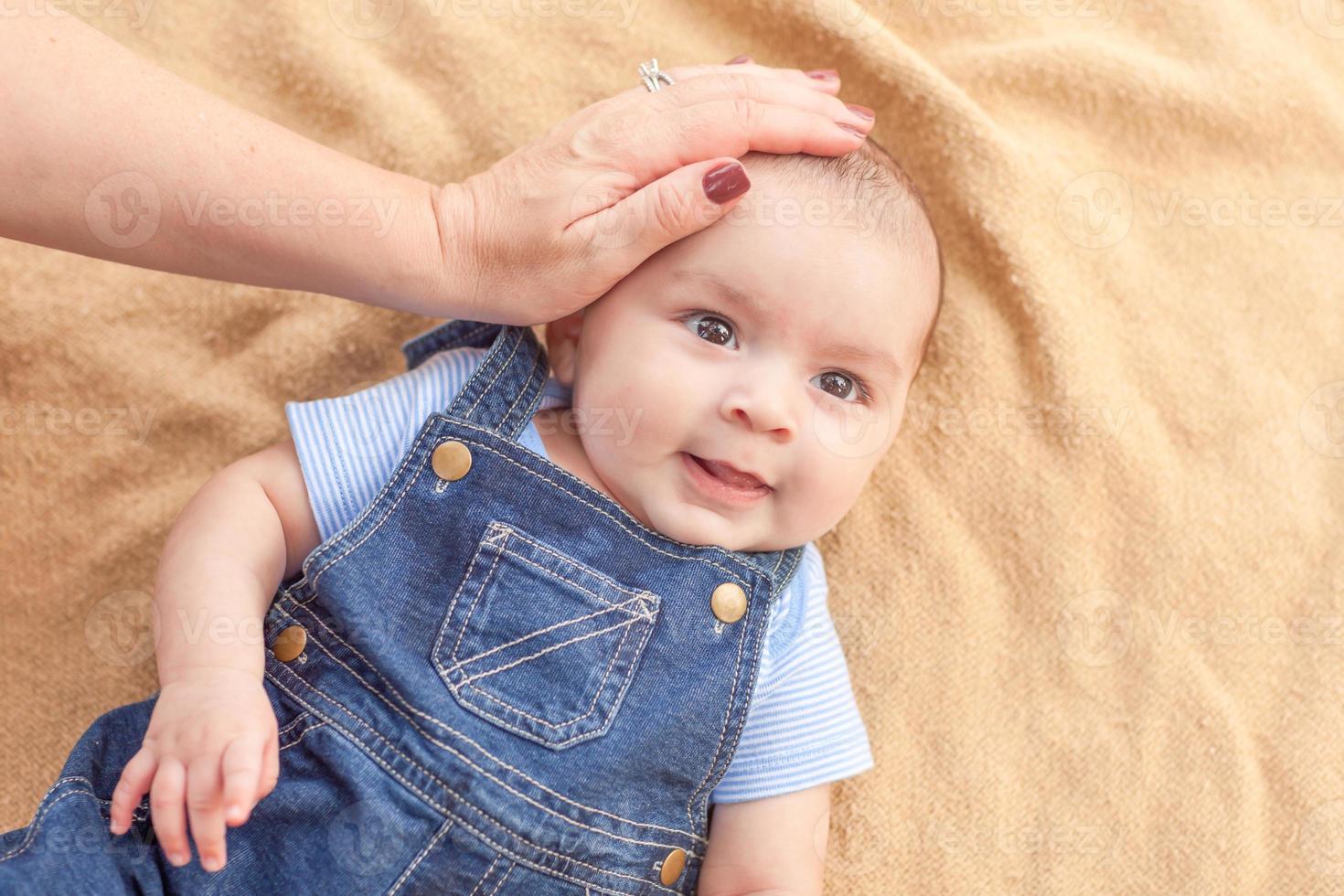 Happy mixed race baby boy portant sur couverture photo