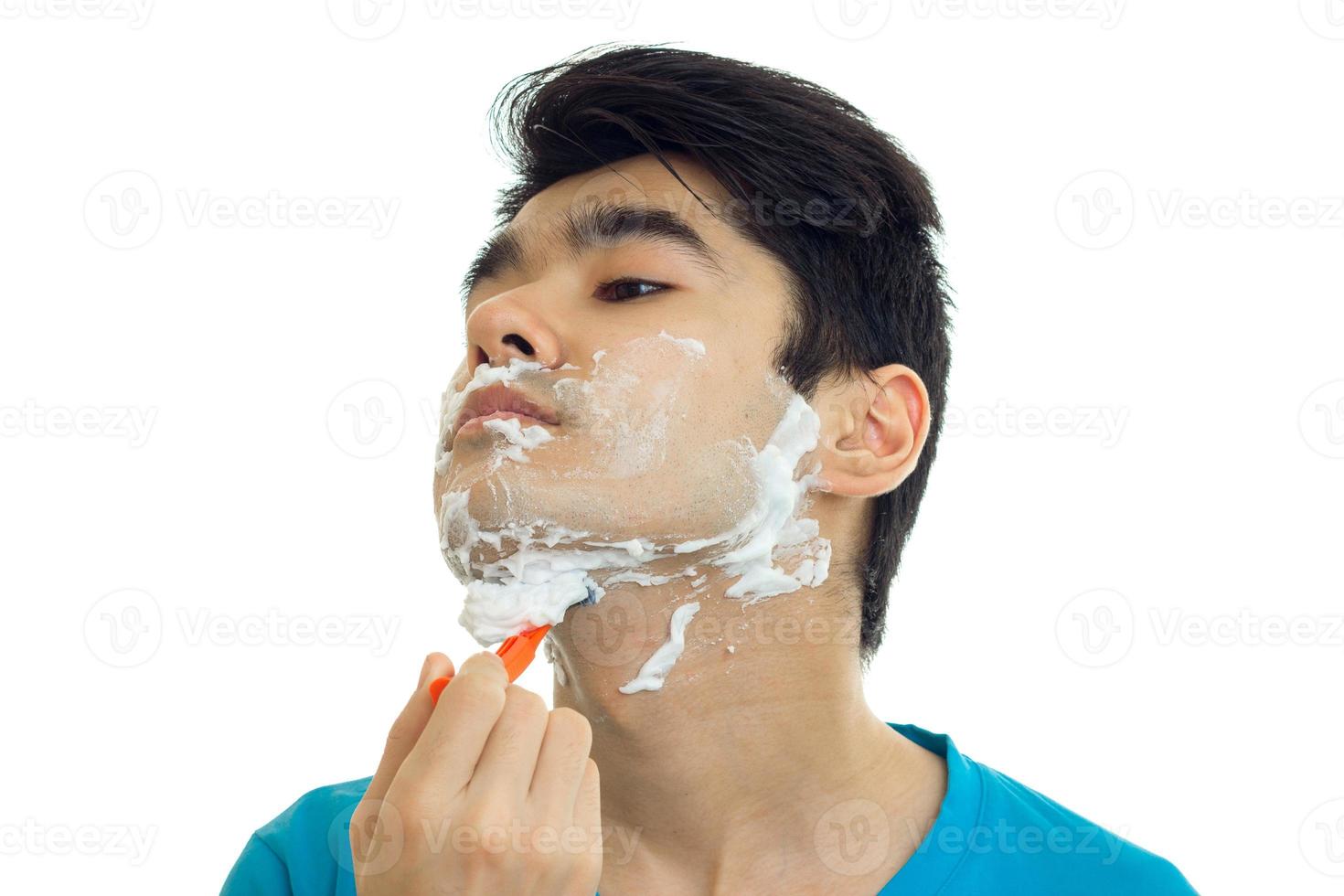 jeune homme a levé la tête et se rase la barbe en gros plan photo