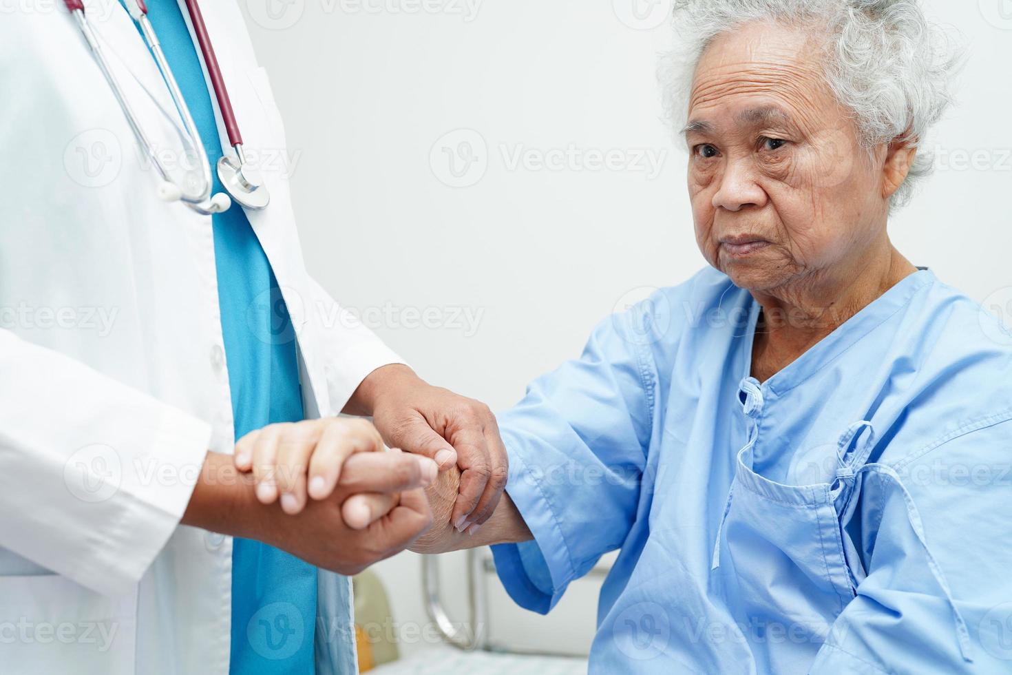 médecin tenant par la main une patiente âgée asiatique, aide et soins à l'hôpital. photo