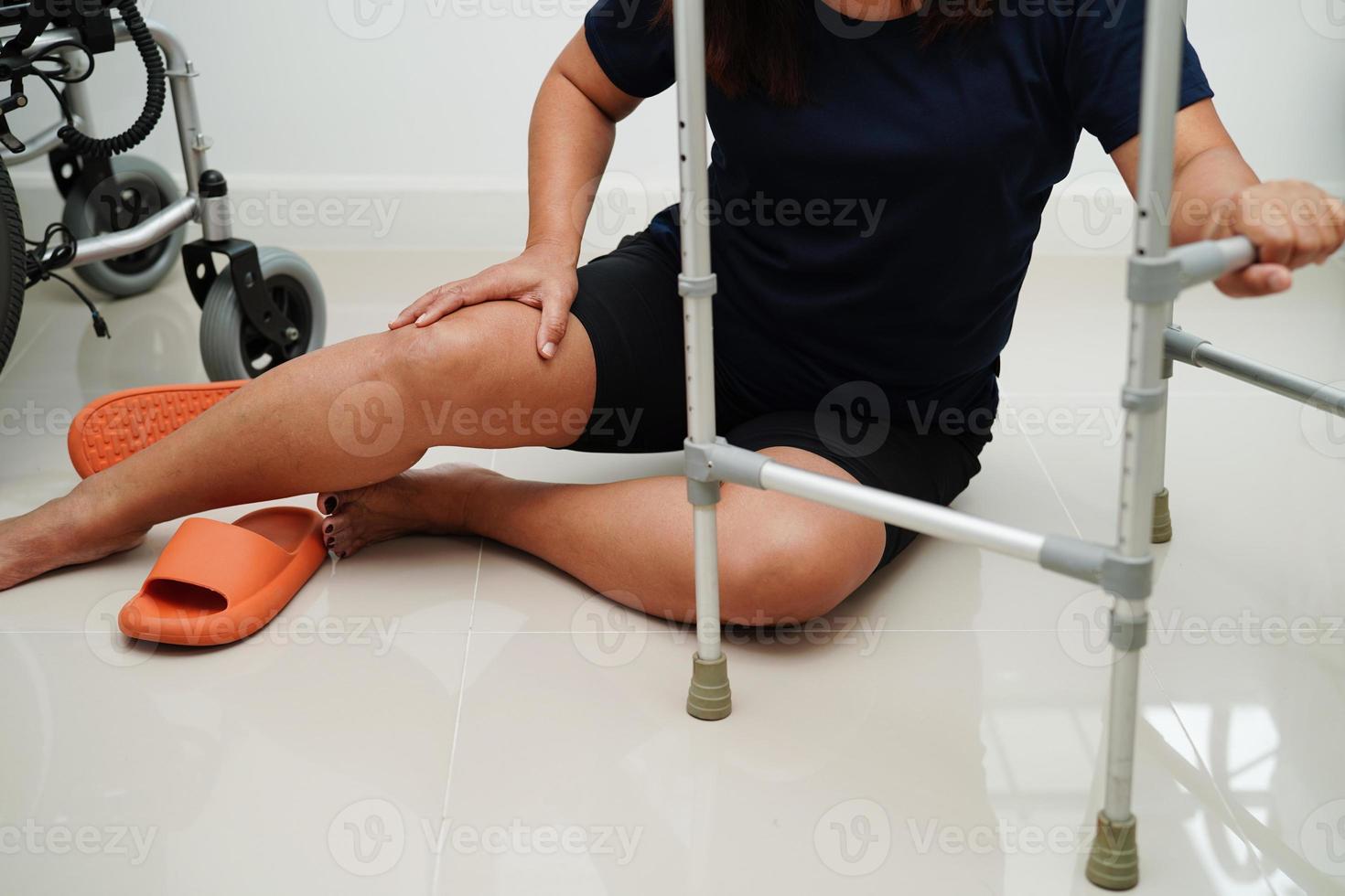 blessure d'une femme asiatique en tombant sur des surfaces glissantes avec une marchette à la maison. photo