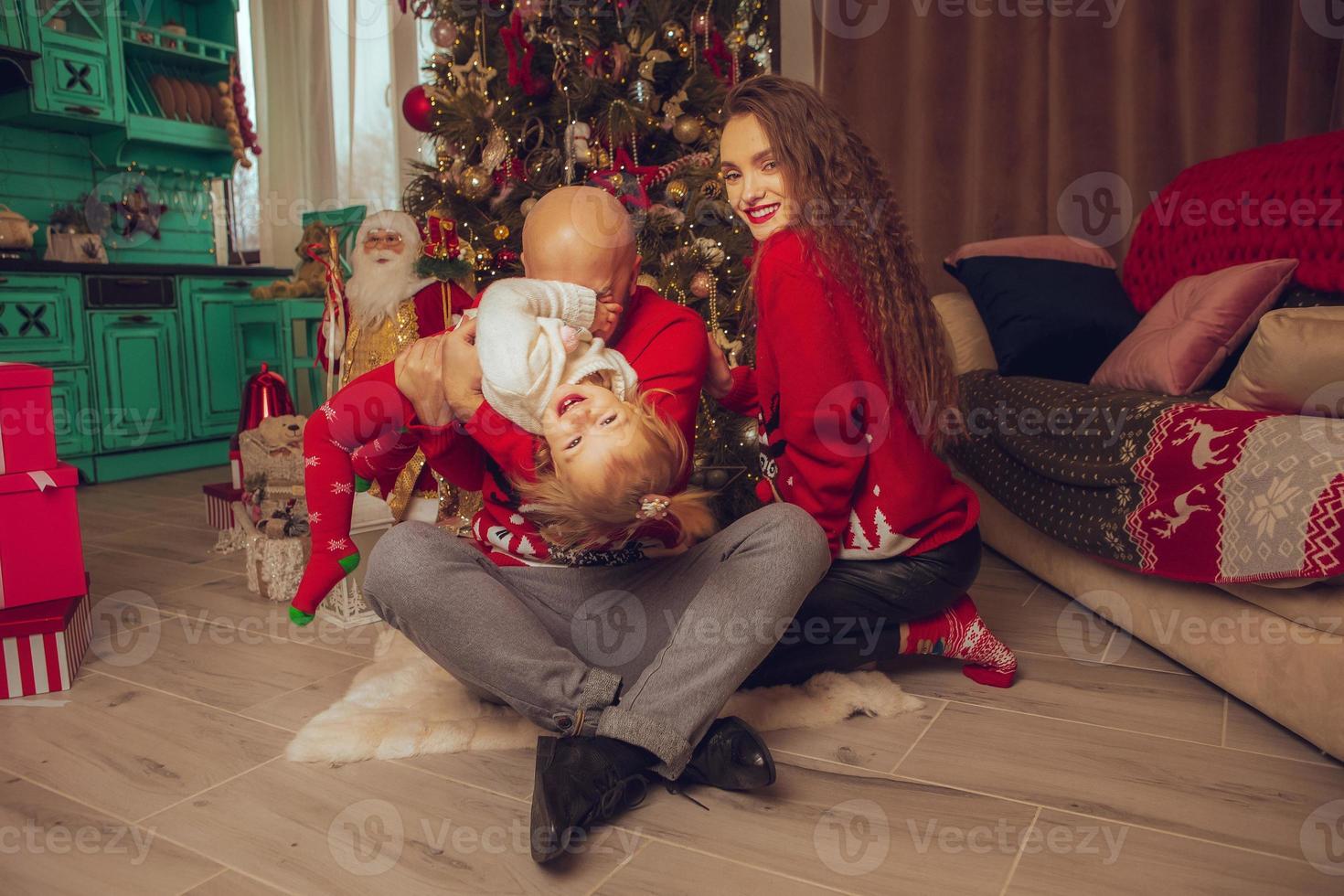 photo horizontale d'une famille amusante avec sa fille fêter le nouvel an et noël ensemble à la maison