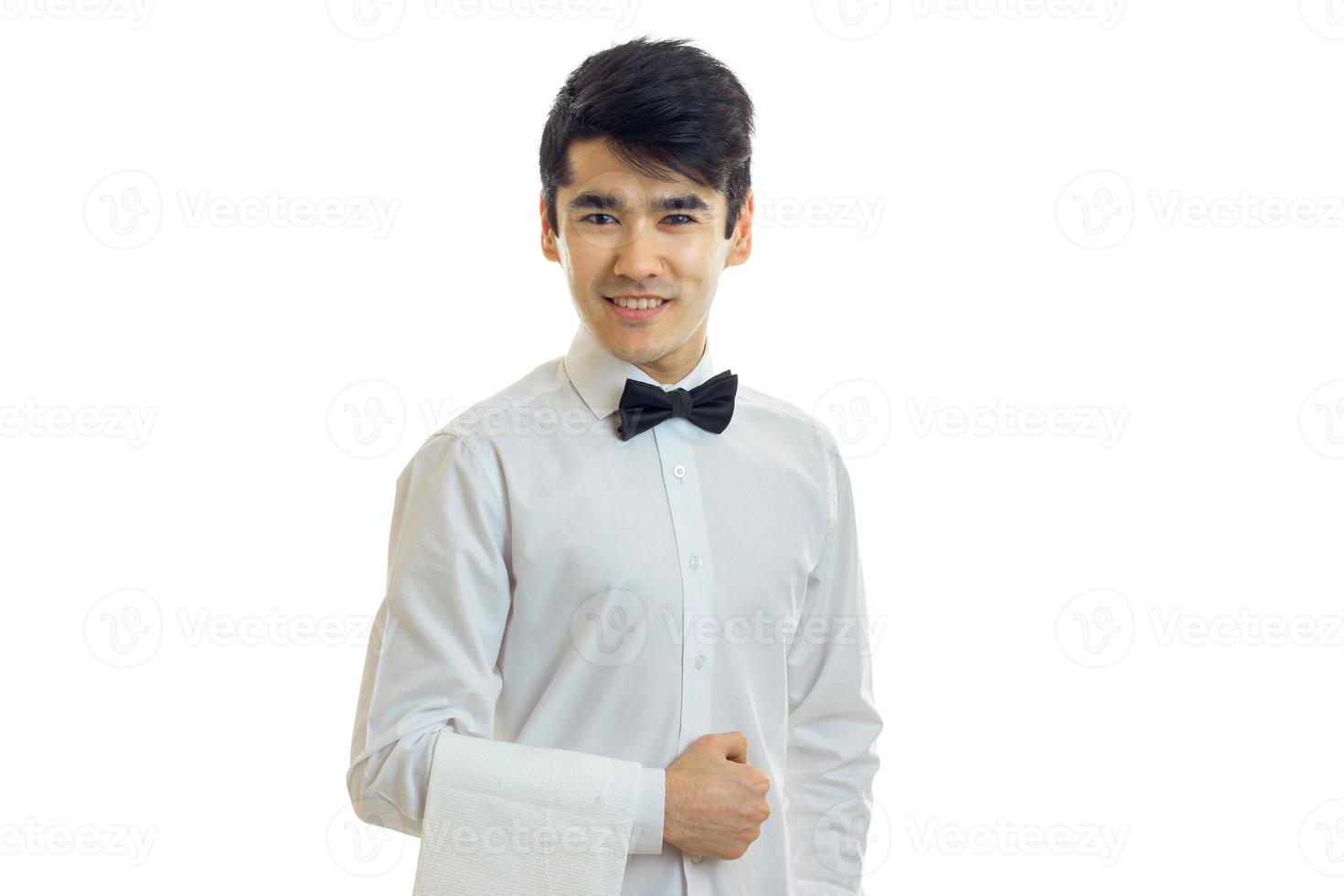 joyeux jeune homme serveur en uniforme avec noeud papillon souriant à la caméra photo