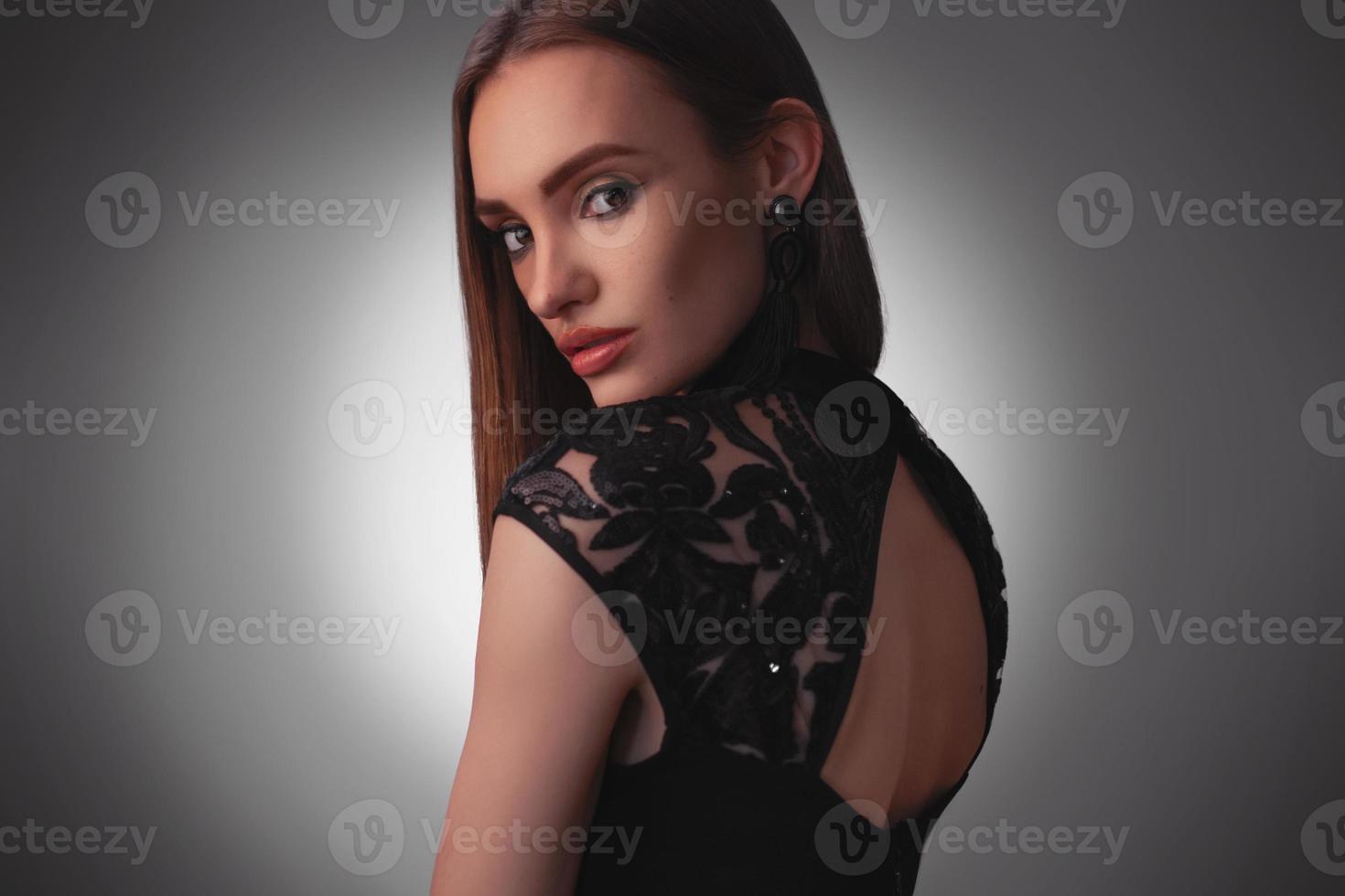 sexy jeune femme en robe noire en studio photo