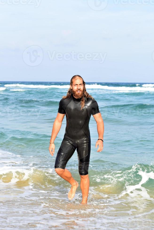 homme sortant de l'océan après avoir surfé sur l'eau photo