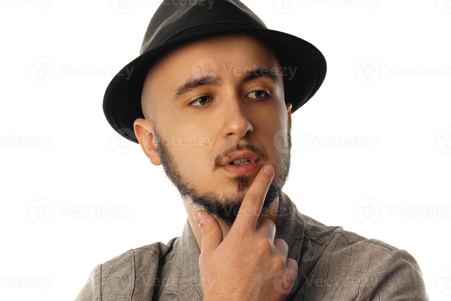 jeune homme non rasé en chapeau et veste regardant de côté photo