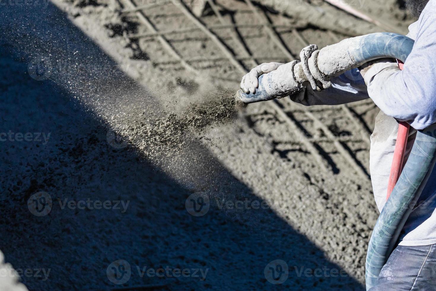 ouvrier en construction de piscine tirant sur du béton, du béton projeté ou de la gunite à travers un tuyau photo