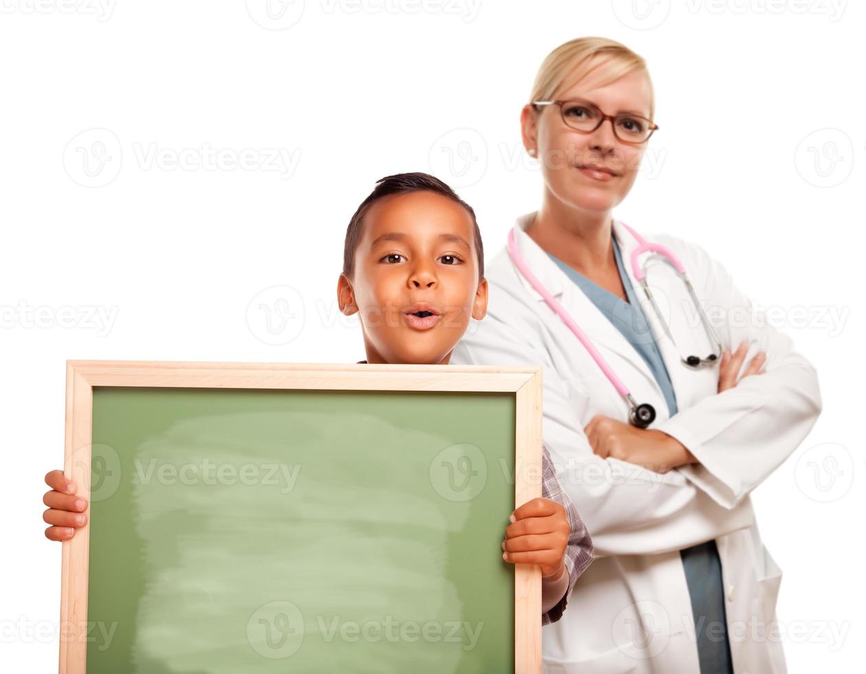 femme médecin avec un enfant hispanique tenant un tableau de craie photo