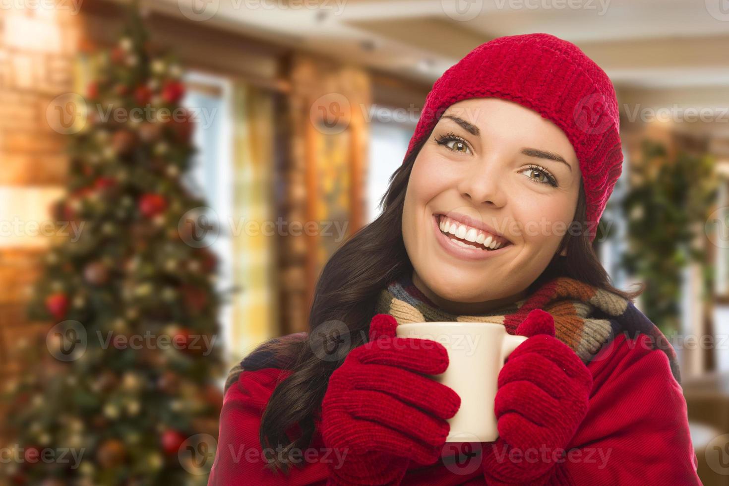 femme de race mixte portant un chapeau et des gants dans un décor de noël photo