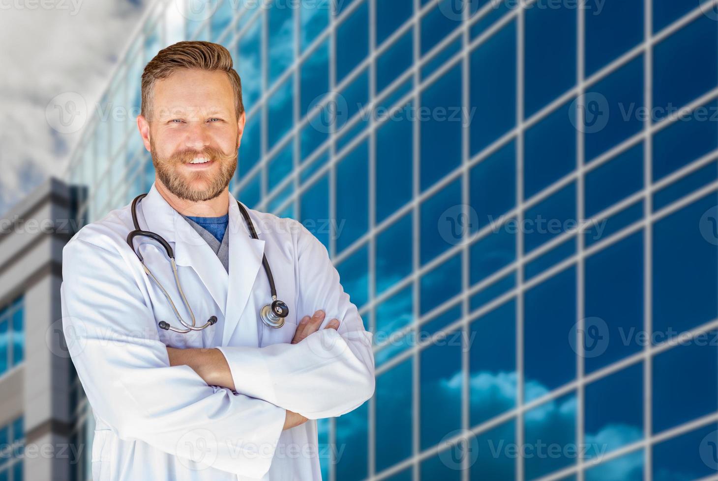 beau jeune homme adulte médecin avec barbe devant le bâtiment de l'hôpital photo