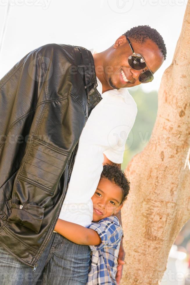 heureux père afro-américain et fils métis jouant au parc photo