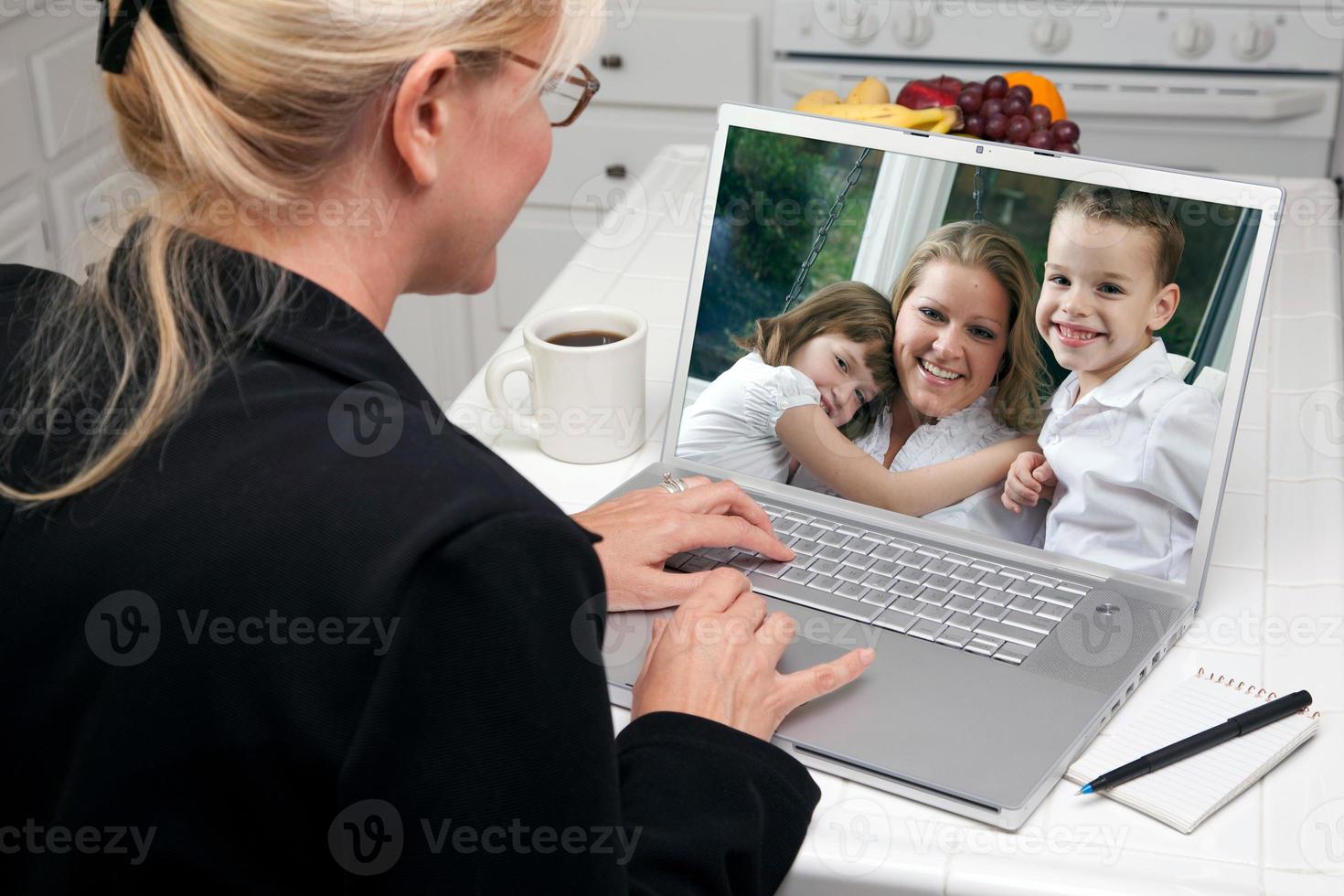 femme dans la cuisine à l'aide d'un ordinateur portable - famille et amis photo