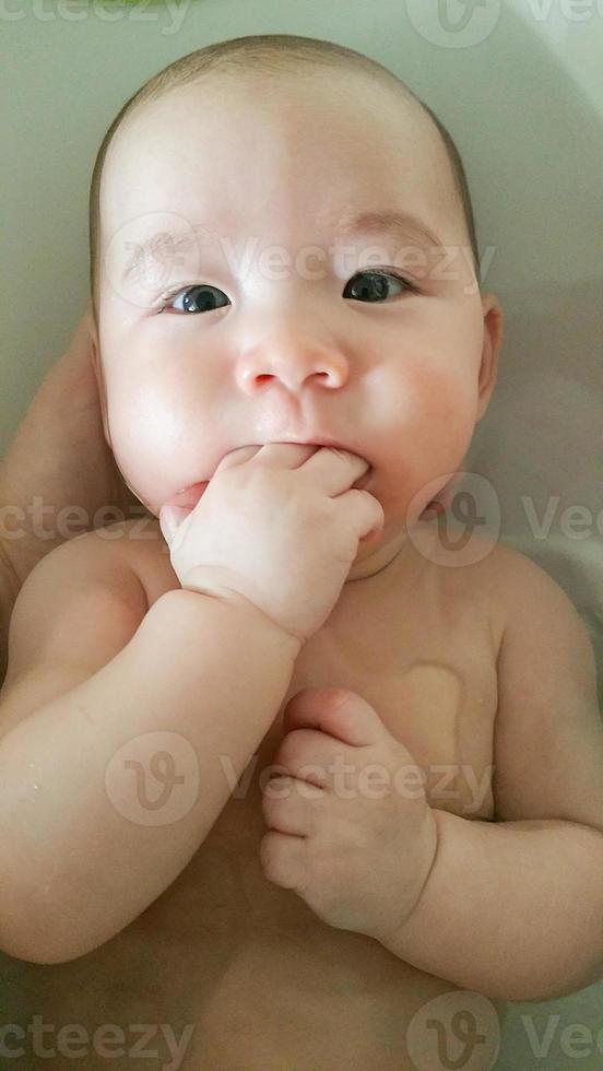 adorable petit garçon chinois et caucasien jouant à prendre un bain photo