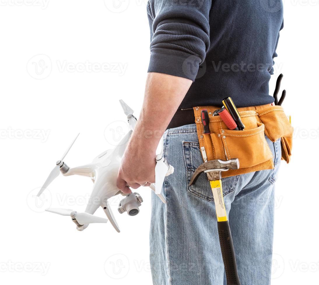 Ouvrier du bâtiment et pilote de drone avec ceinture à outils tenant un drone isolé sur fond blanc photo