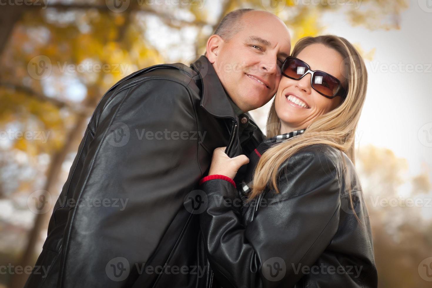 beau couple dans un parc avec des vestes en cuir photo