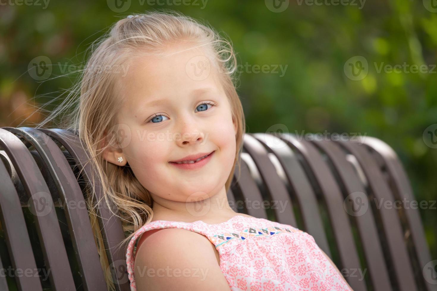 jolie jeune fille caucasienne portrait assis sur le banc au parc photo