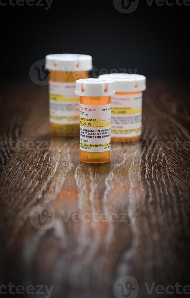 variété de flacons de médicaments sur ordonnance non exclusifs sur une surface en bois réfléchissante. photo