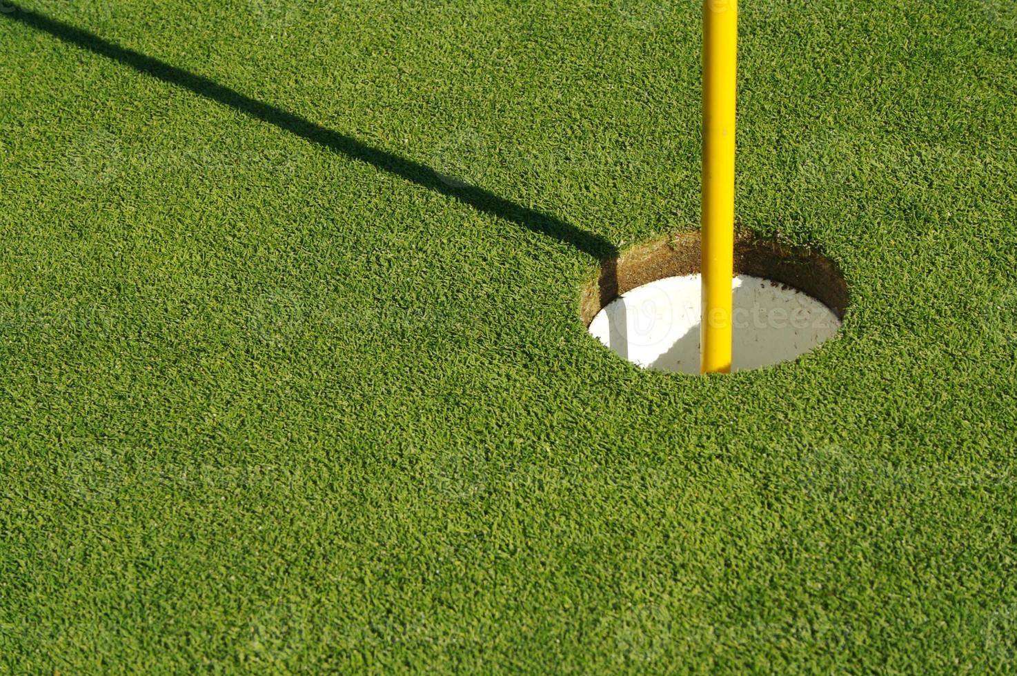 vert de golf et drapeau luxuriants et fraîchement tondu photo