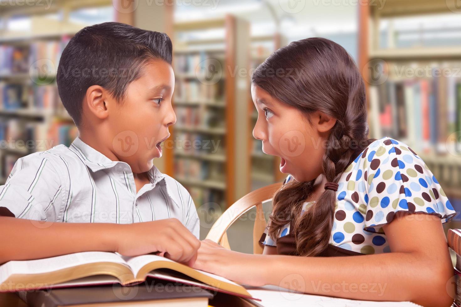 garçon et fille hispaniques s'amusant à étudier ensemble à la bibliothèque photo