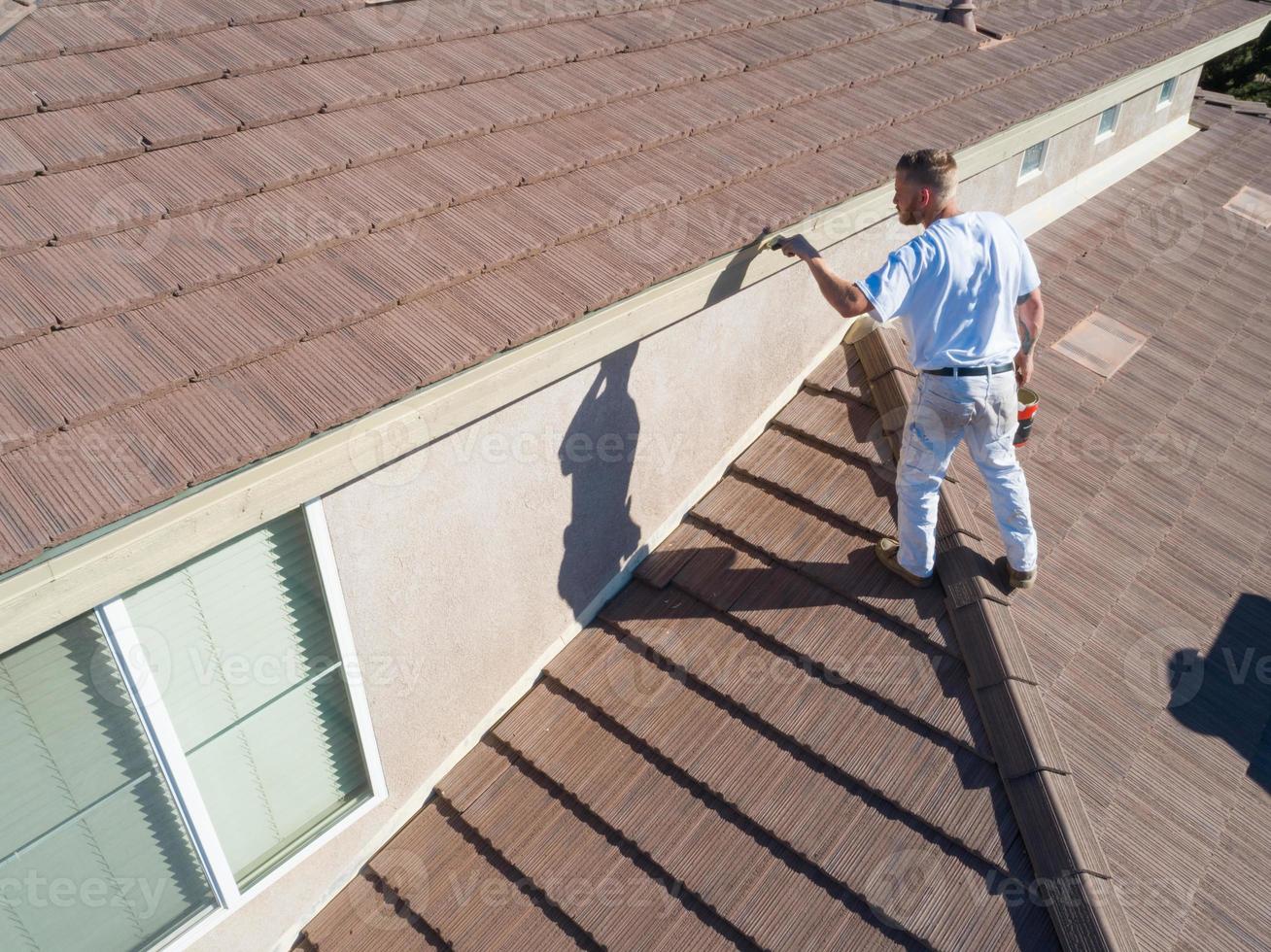 peintre professionnel utilisant un pinceau pour peindre le fascia de la maison photo