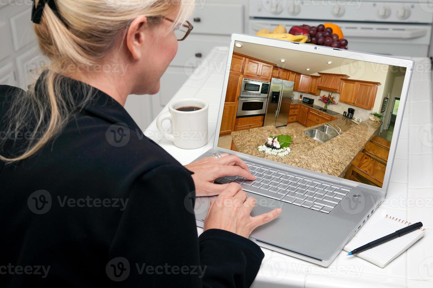 femme dans la cuisine à l'aide d'un ordinateur portable - amélioration de l'habitat photo