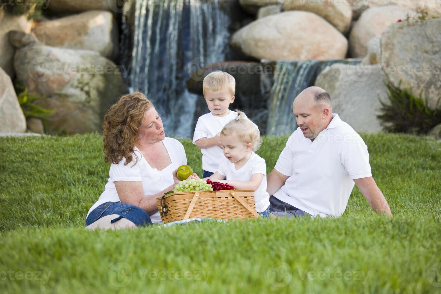 une jeune famille heureuse profite d'un pique-nique dans le parc photo