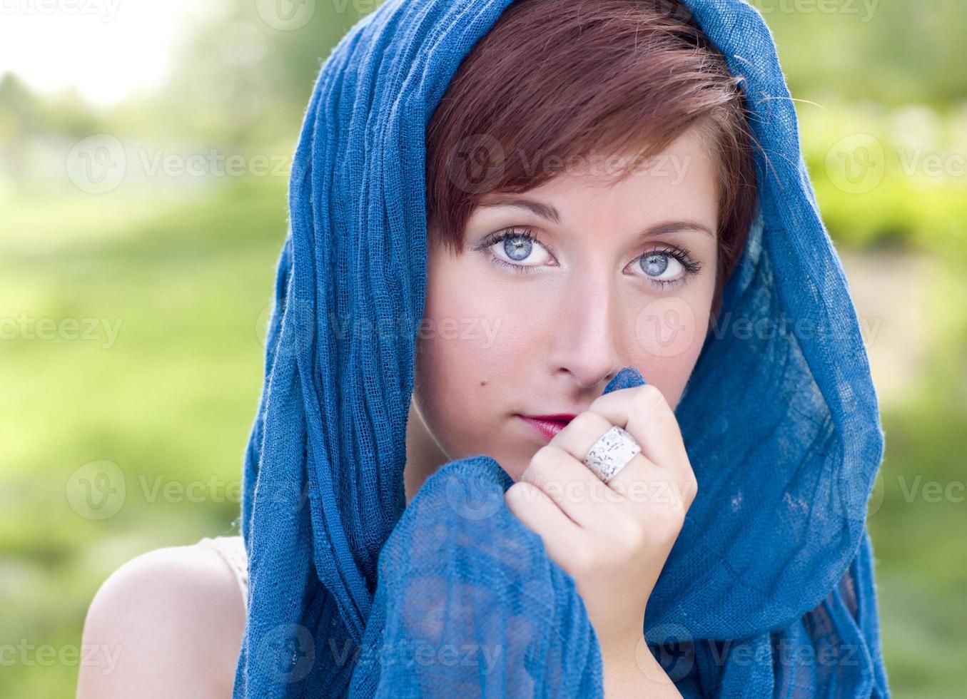 Jolie jeune femme aux yeux bleus aux cheveux rouges portrait en plein air photo
