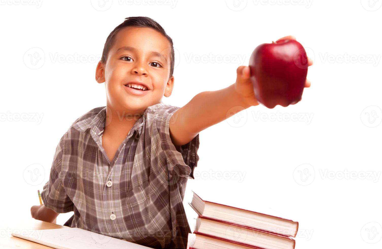 adorable garçon hispanique avec livres, pomme, crayon et papier photo