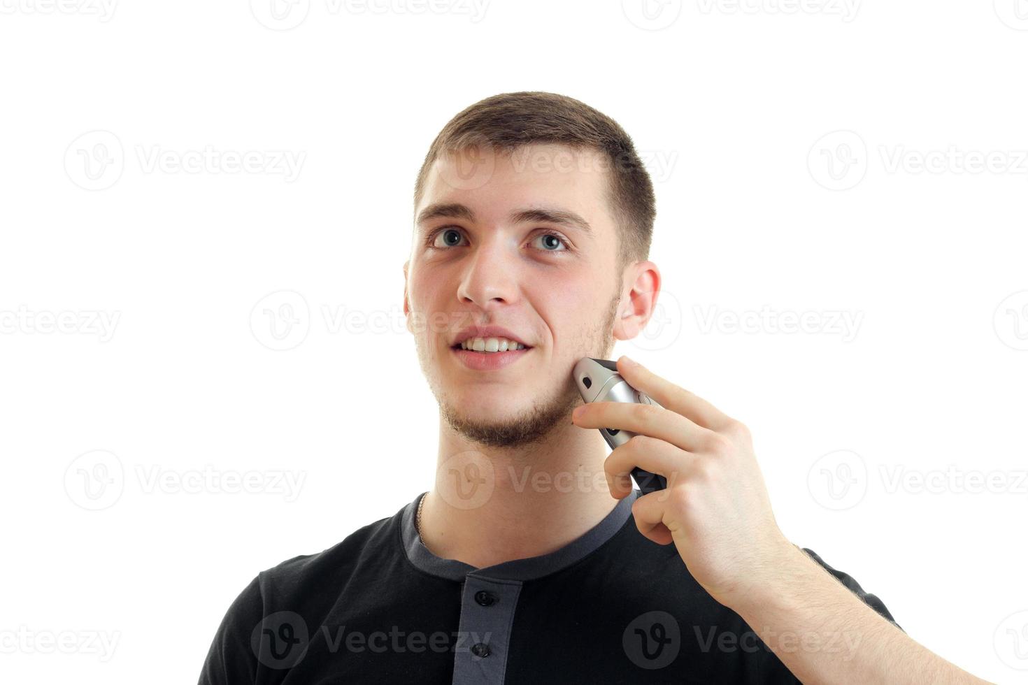 Guy charismatique lève les yeux et se rase la barbe est isolé sur fond blanc photo