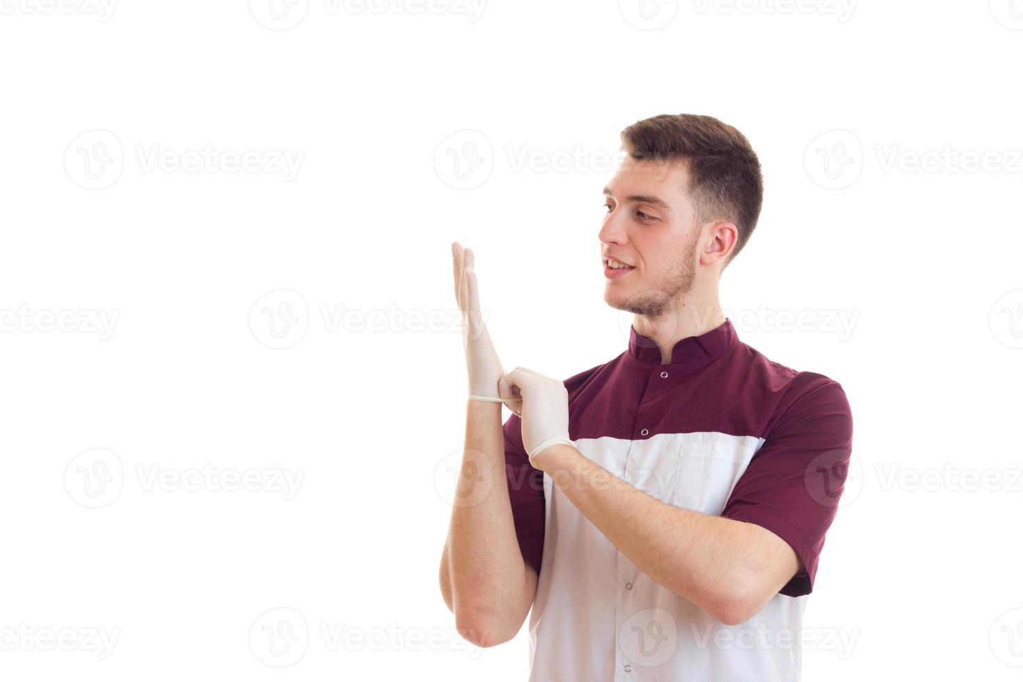 un jeune assistant de laboratoire met des mains de gants blancs photo