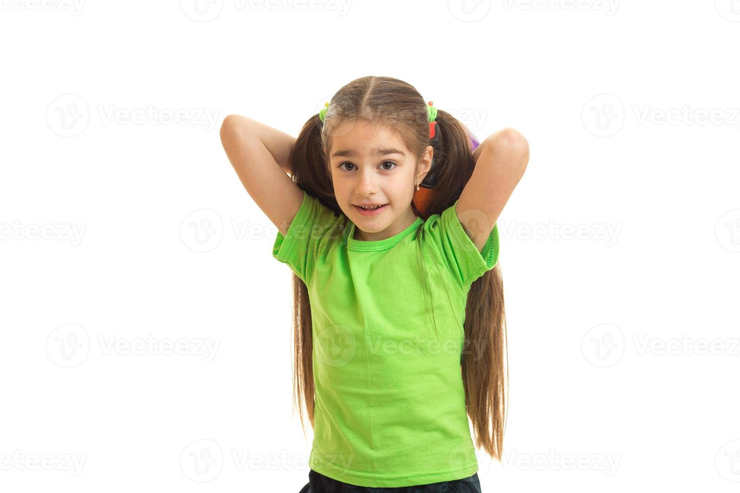 heureuse petite fille jouant un match de football avec un ballon et souriant photo