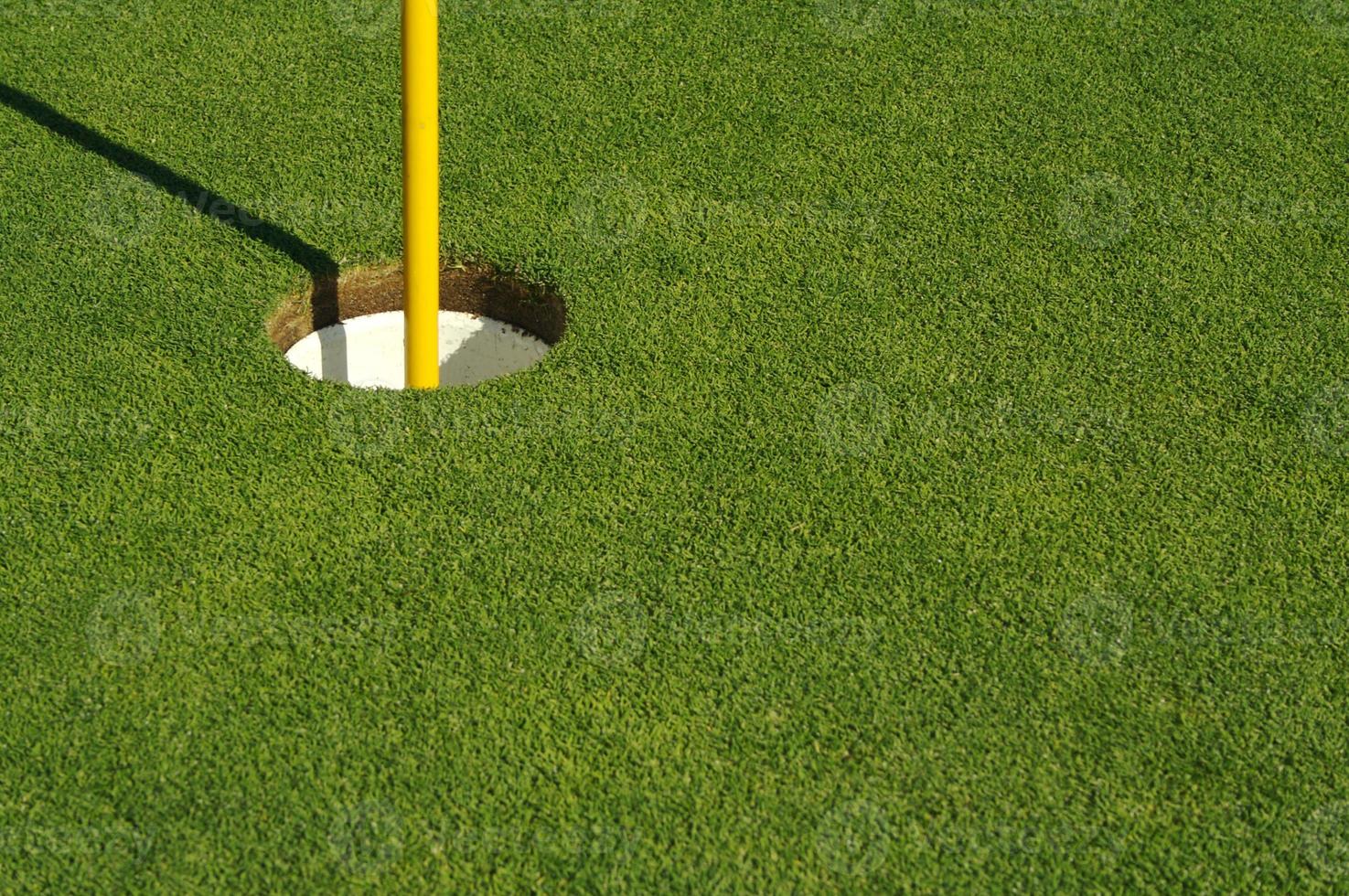 vert de golf et drapeau luxuriants et fraîchement tondu photo