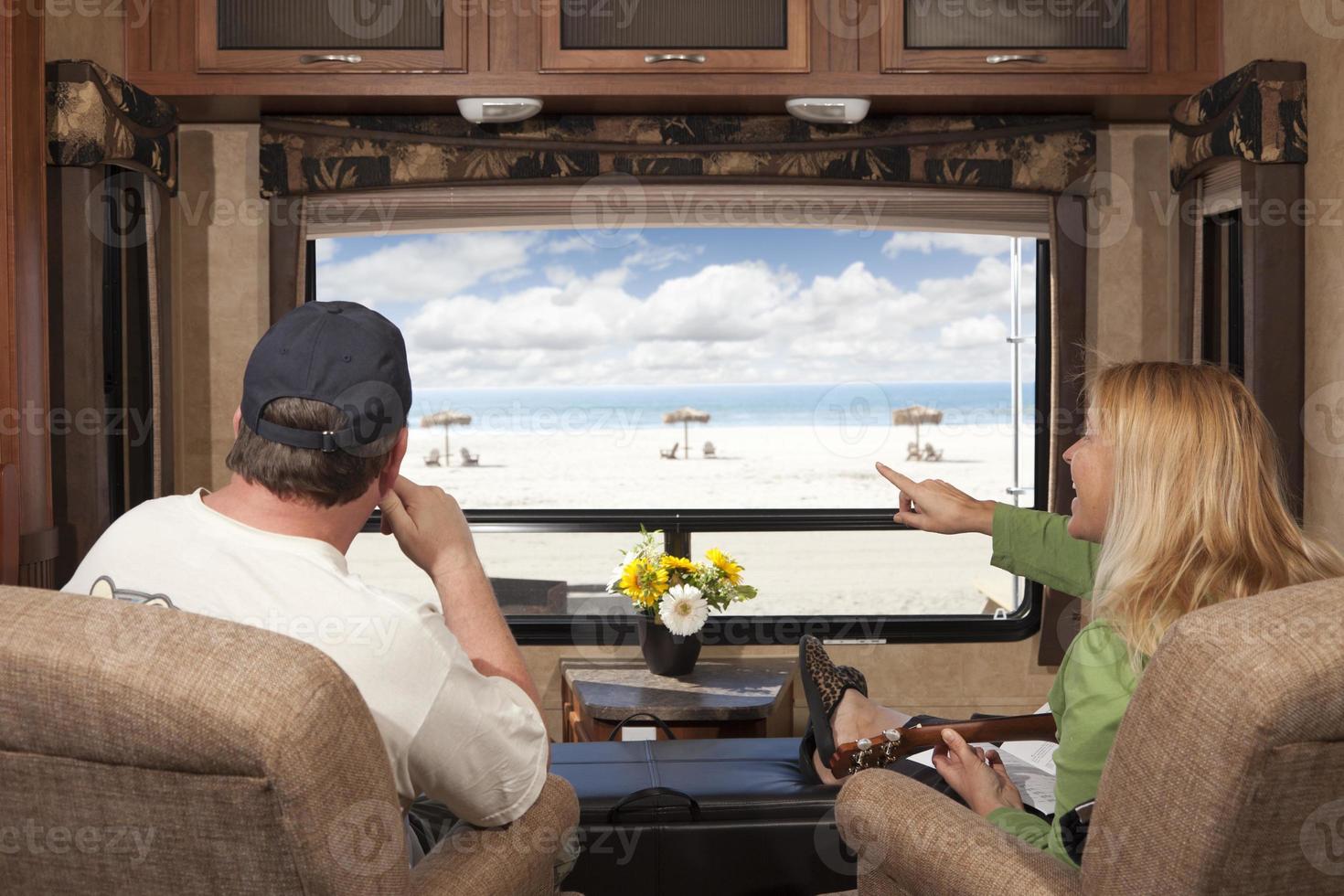 couple profiter de la vue sur la plage depuis le camping-car photo