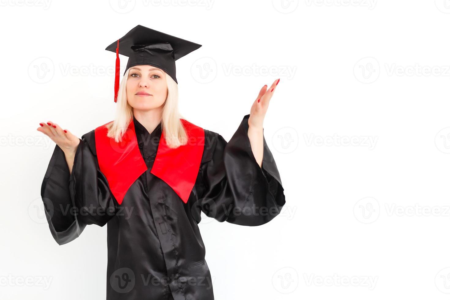 une étudiante diplômée heureuse et excitée se tient debout dans le manteau, souriant et regardant la caméra photo