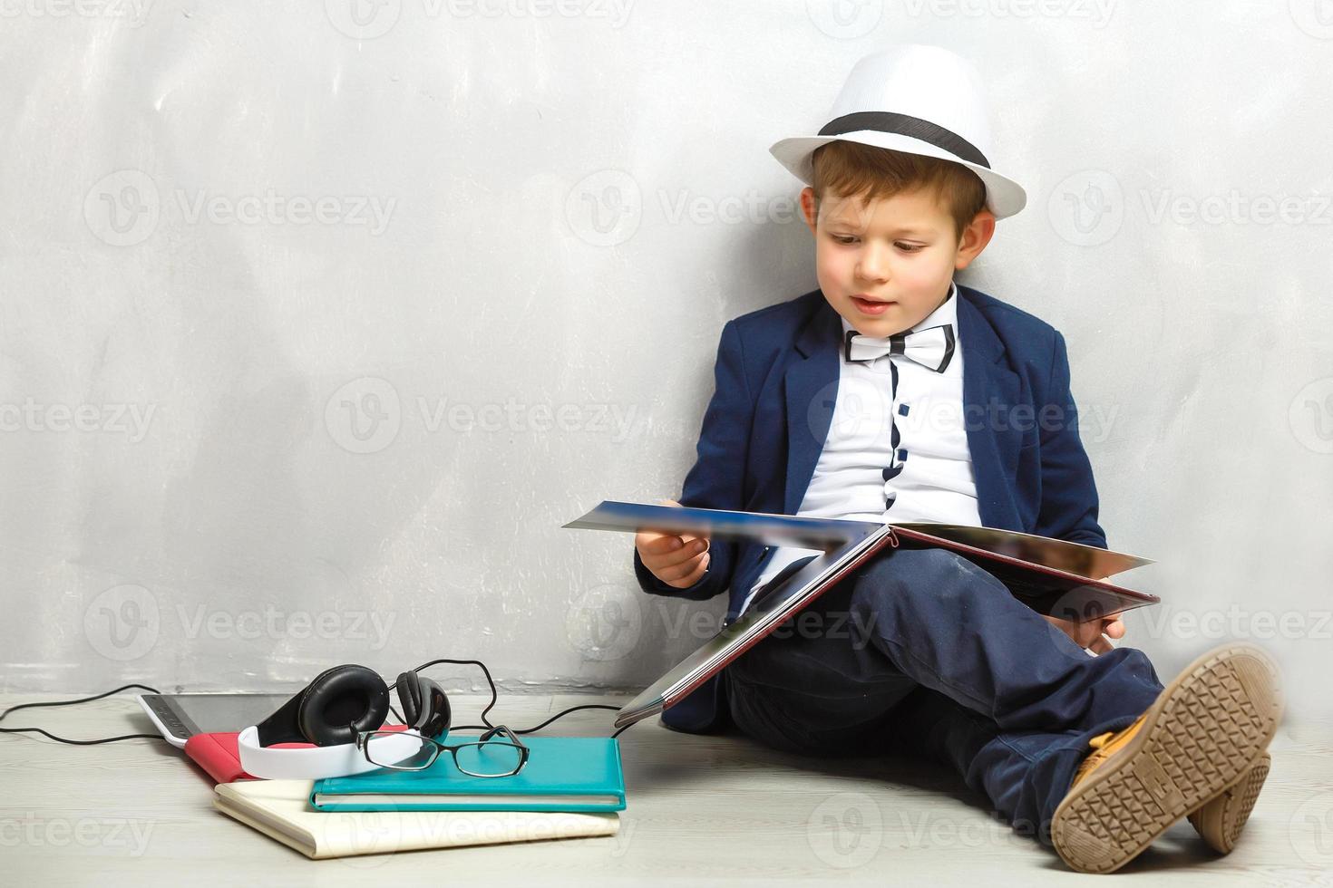 Heureux enfant curieux petit garçon génie sur fond gris photo