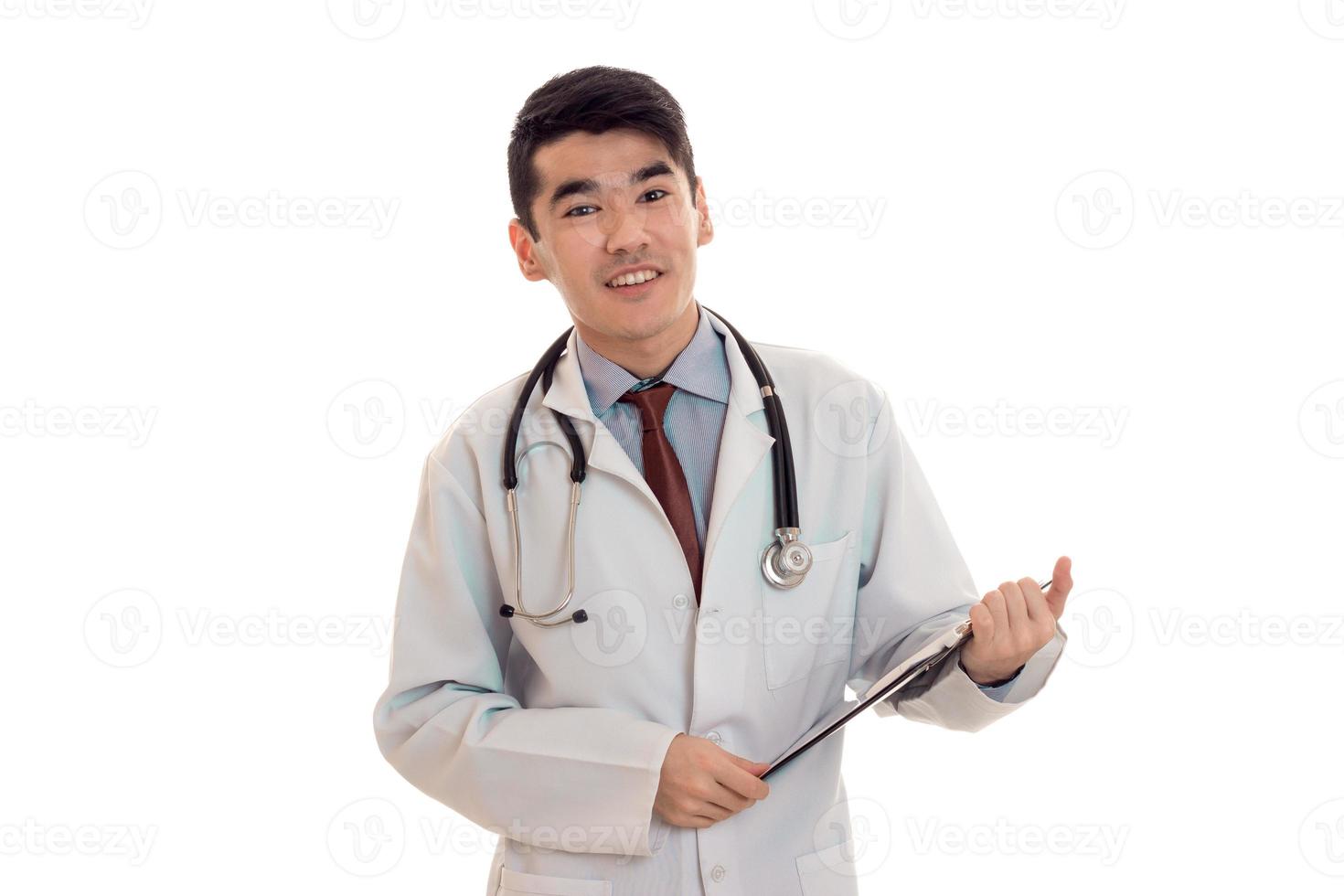 Jeune médecin de sexe masculin joyeux avec stéthoscope en uniforme isolé sur fond blanc photo