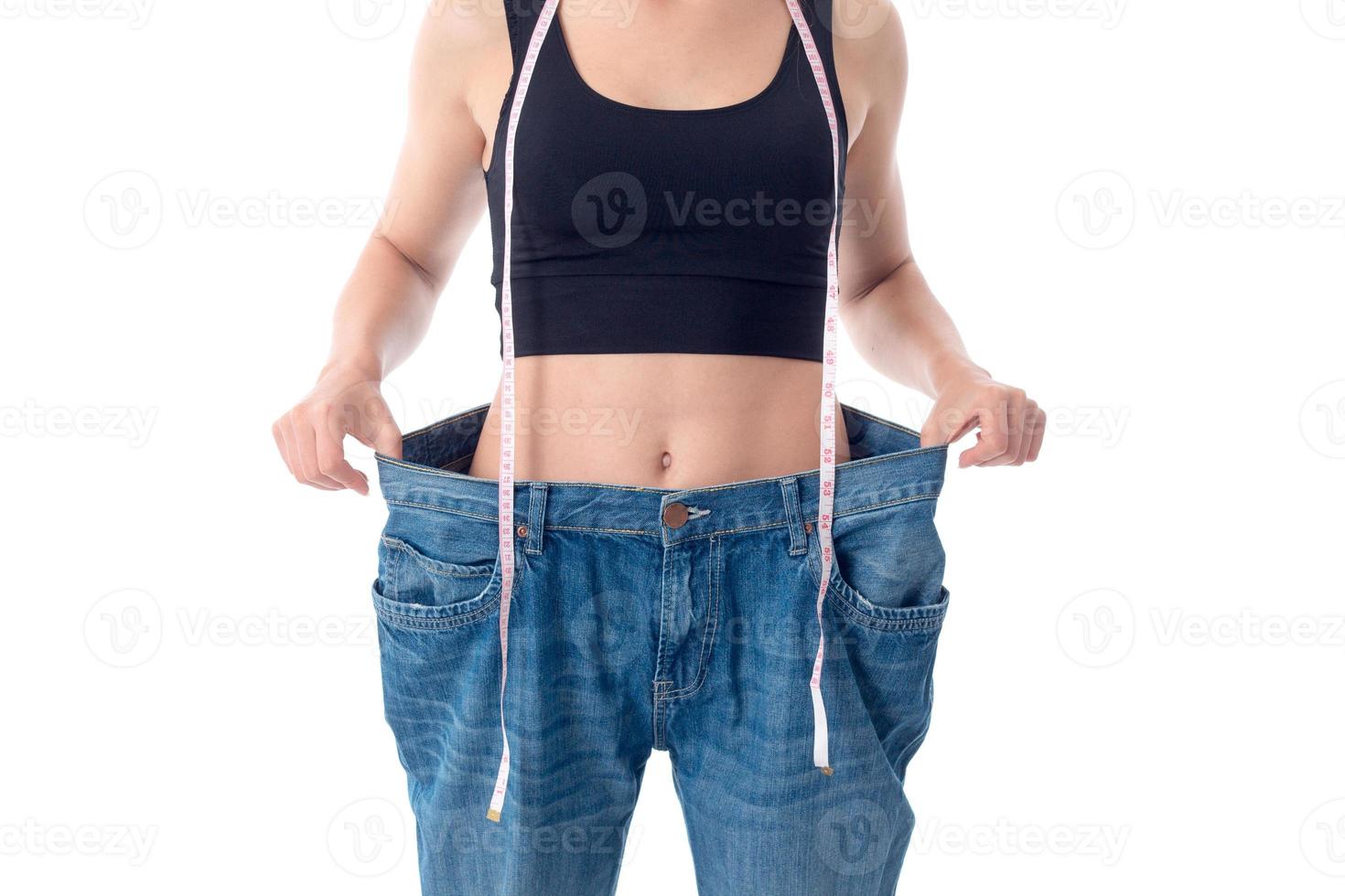 fille mince se tient dans un énorme pantalon en denim en gros plan photo